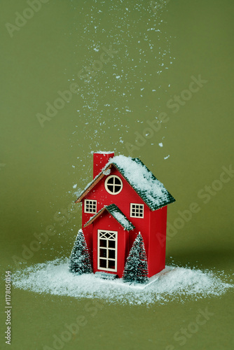 snow falling on a red toy house photo