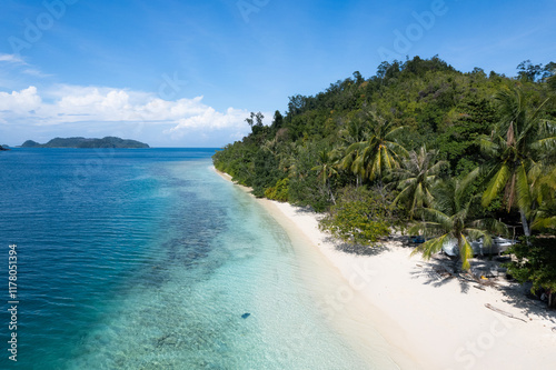 Tropical shoreline with clear blue water and a white sandy beach photo