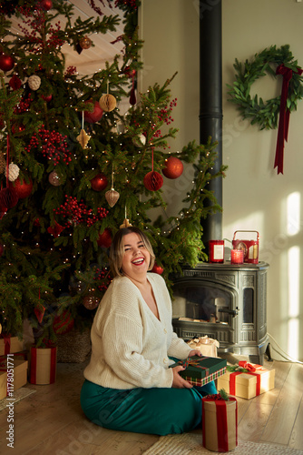 Cheerful woman holding a Christmas gift photo