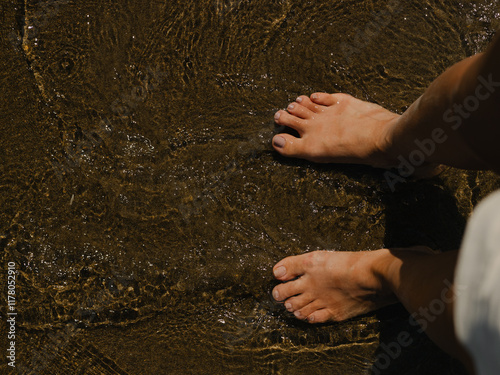 A person enjoying the soothing water on a sandy beach  photo