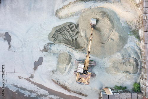 Aerial View of Excavator Moving Sand on Construction Site photo