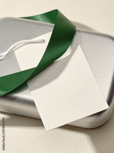 Silver gift box with green ribbon and blank tag ready for gifting photo