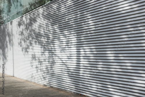 Metal wall with shadow reflection of tree. Urban city environment photo