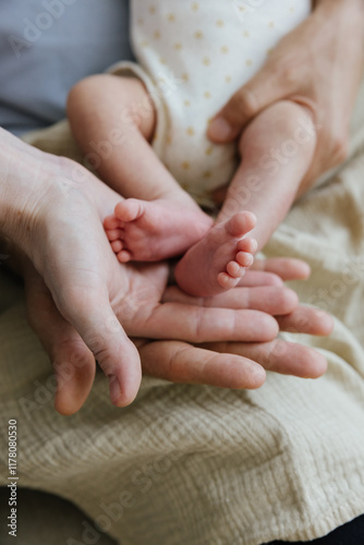 Parents holding newborn baby's feet in their hands photo