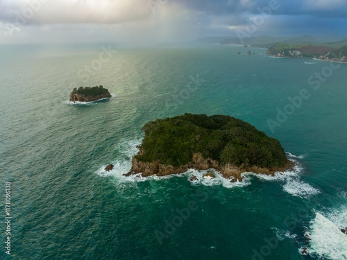 Aerial view of lush islands, dramatic waves, and a cloudy sky. Coastal landscape. Whenuakura Island, Whangamata, Coromandel Peninsula, NZ photo