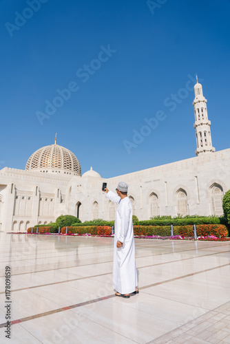 Omani man taking selfie at sultan qaboos grand mosque muscat oman photo