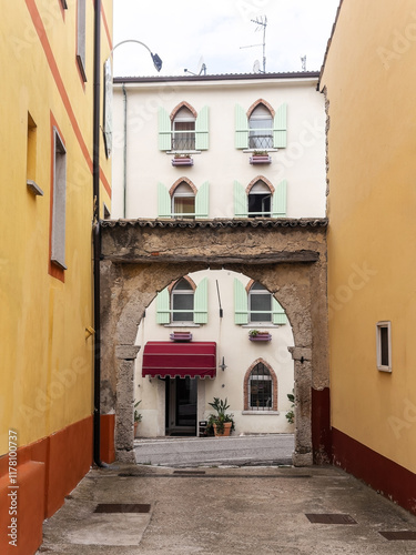 Italian hotel seen through a beautiful stone arch on a street photo