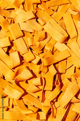 Closeup macro view of raw orange tagliatelle noodle strips photo