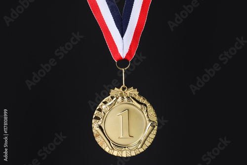 Golden medal with striped ribbon on black background photo