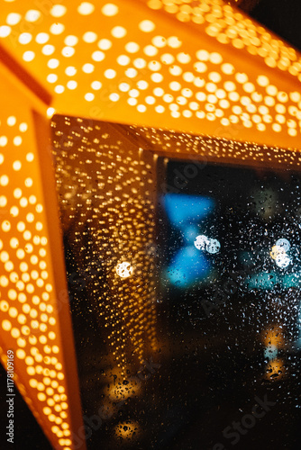 Bright lantern casting reflections in rainy window at night photo