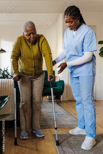 Nurse assisting elderly woman using crutches at home