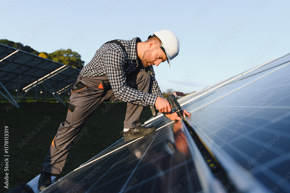Man worker mounting photovoltaic solar panels. Engineer in helmet installing solar module system. Concept of alternative, renewable energy Man worker mounting photovoltaic solar panels. Engineer in helmet installing solar module system. Concept of alternative, renewable energy