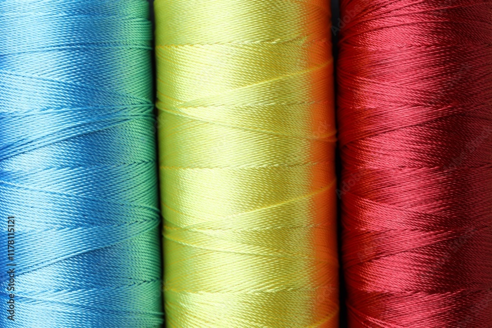 Spools of bright sewing threads as background, top view Spools of bright sewing threads as background, top view