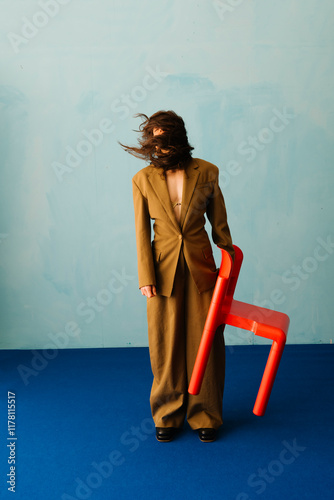 Creative Portrait of Person Holding Bright Red Chair photo