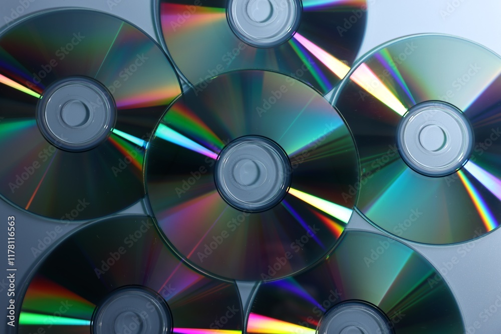 Many shiny compact discs on dusty blue background, flat lay Many shiny compact discs on dusty blue background, flat lay
