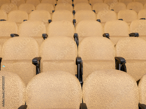 View of brightly lit yellow lecture seats, one with gum photo