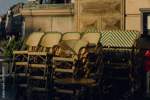 Chairs stacked in a quiet urban setting during late afternoon sunlight photo