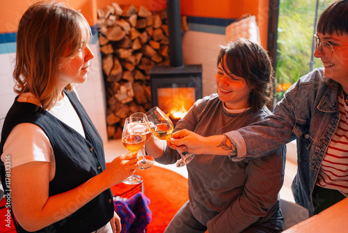 Friends Toasting with Wine in Cozy Interior by Fireplace photo