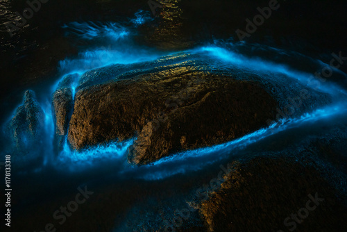Bioluminescence from micro marine organisms. Shallow water on rocks. 