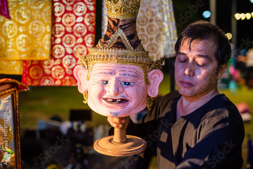 Thai Artisan Arranging a Sacred Hermit Mask photo