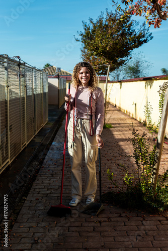 Volunteer cleaning outdoor walkway near kennels in animal shelter photo