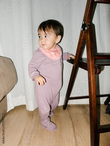 UGC Girl learning to walk, clinging to a wooden chair