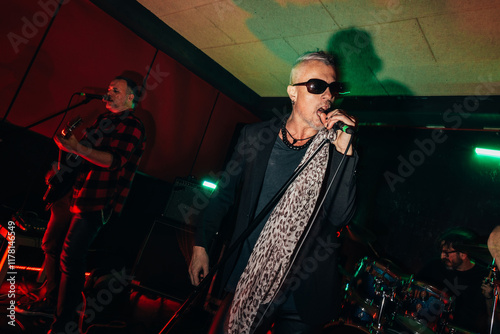 Energetic rock band performing live in dimly lit venue photo