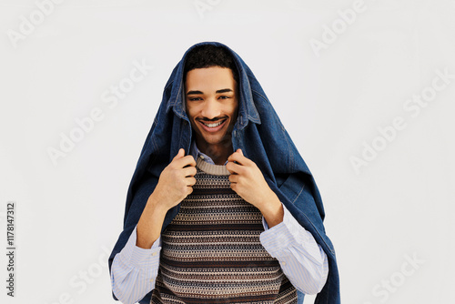 Stylish man wearing denim jacket on head smiling at camera photo