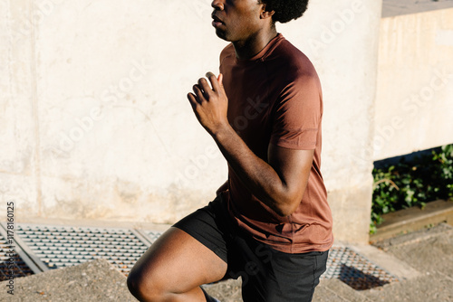 Fit man performing leg-focused functional exercises on a staircase photo
