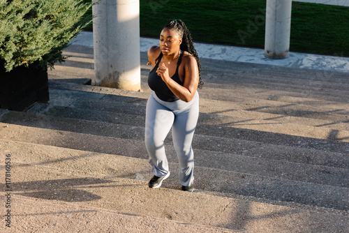 Curvy woman exercising on an outdoor staircase in a Madrid park photo