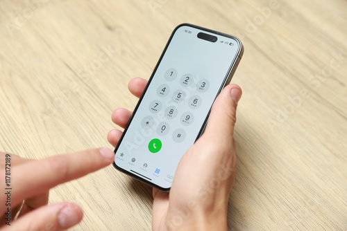 Wallpaper Mural Man dialing number on smartphone at wooden table, closeup Torontodigital.ca