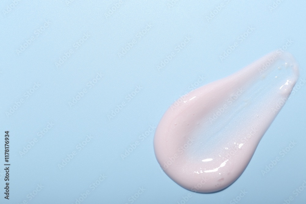Cream sample on light blue background, top view. Space for text Cream sample on light blue background, top view. Space for text