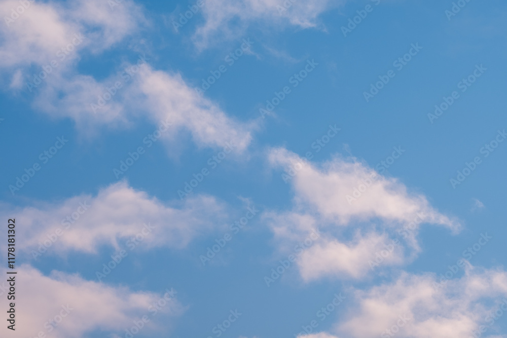 Fototapeta premium Soft white clouds drift across a vibrant blue sky creating a serene and peaceful atmosphere