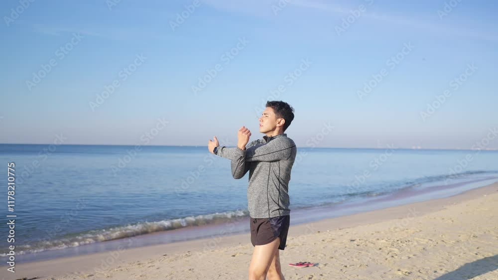 Asian man in sportswear stretching body after jogging exercise at tropical island beach. Healthy guy enjoy outdoor active lifestyle sport training running fitness workout on summer holiday vacation. Asian man in sportswear stretching body after jogging exercise at tropical island beach. Healthy guy enjoy outdoor active lifestyle sport training running fitness workout on summer holiday vacation.