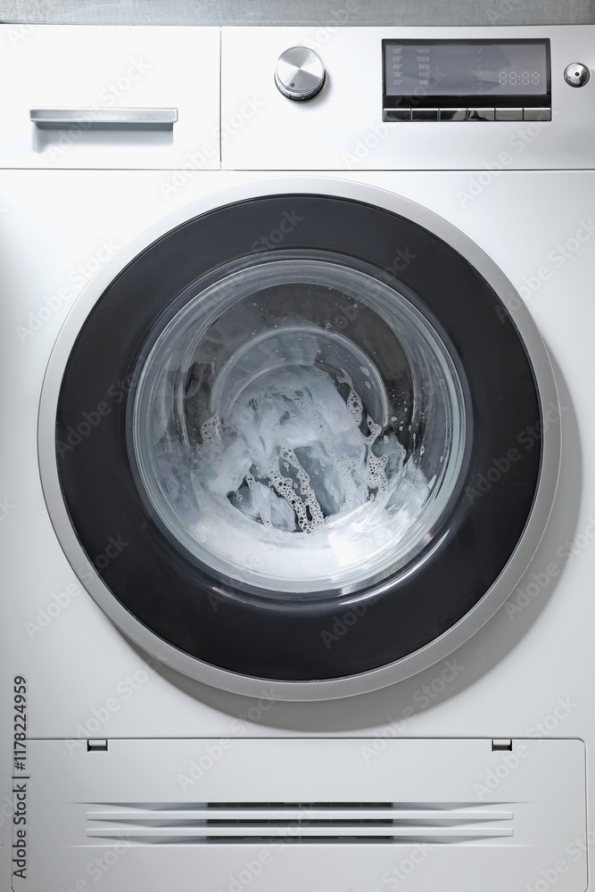 Washing machine with clothes and suds as background, closeup Washing machine with clothes and suds as background, closeup