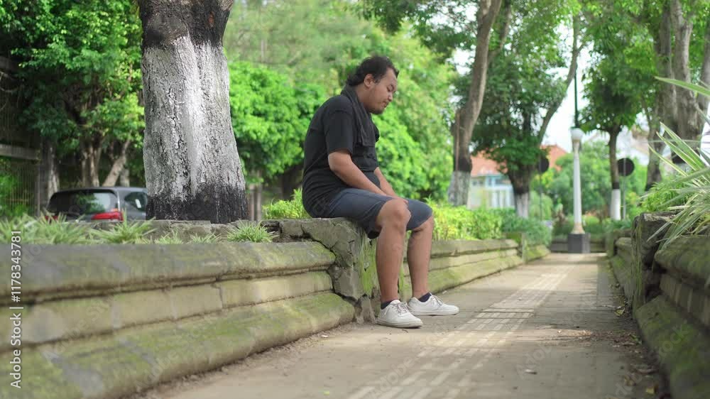 asian fat man drinking water while sitting and resting from exercising asian fat man drinking water while sitting and resting from exercising