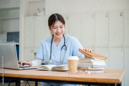 A smart and beautiful Asian female medical student in scrubs is studying in the library.