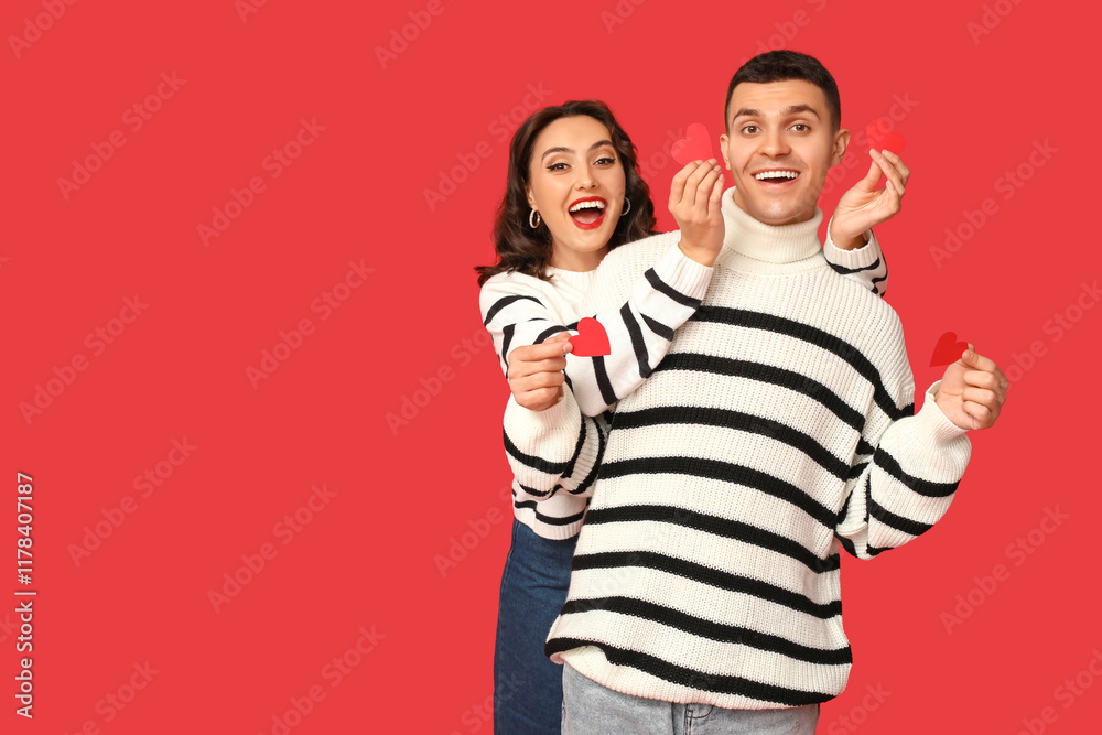 Loving young couple with paper hearts on red background. Celebration of Saint Valentine's Day Loving young couple with paper hearts on red background. Celebration of Saint Valentine's Day