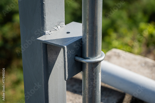 Use U-bolts to fasten the conduit pipe to the angle iron of the steel pole.