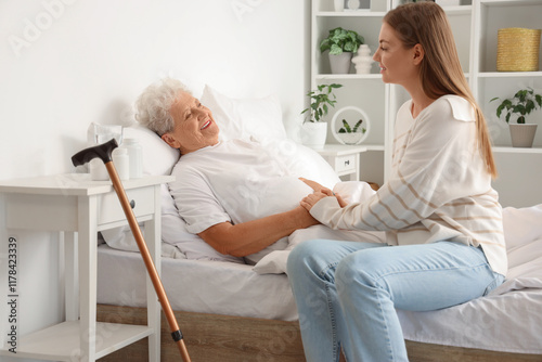 Cuadro en lienzo Young woman taking care of her happy grandmother in bedroom at home