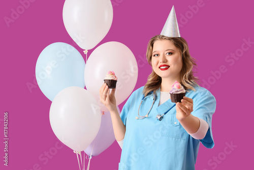Canvas Print Young happy female doctor in party hat with balloons and birthday cupcakes on pu