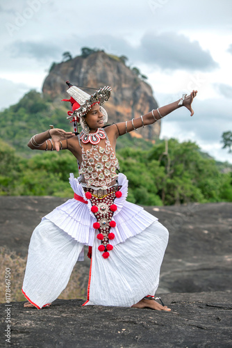 SIGIRIYA, SRI LANKA - JULY 16, 2024 : A Ves Dancer, also known as a Kandyan Dancer or Up Country Dancer performs at Sigiriya in Sri Lanka. In the background stands Sigiriya Rock.