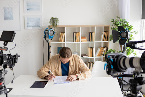 Studio script. Media document. Business man writing paper in bright photo studio workplace. Video shooting art signing important project. photo