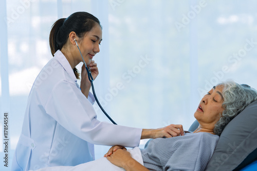 Asian female doctor checking the heart rate of an elderly woman uses a stethoscope to routinely check the health of an elderly woman patient at home. health care concept photo