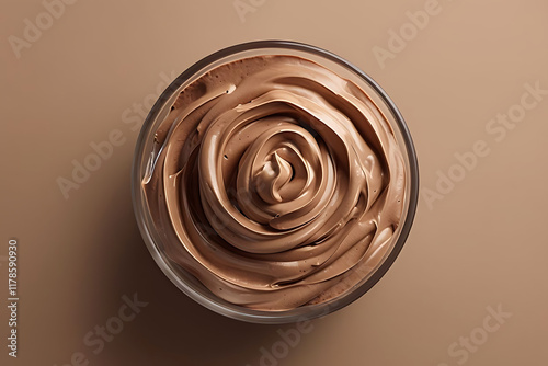 Round Glass Container With Swirled Chocolate Mousse Against Brown Background photo