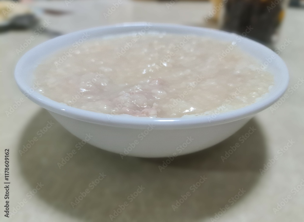 Pork congee in a white ceramic bowl on the table Pork congee in a white ceramic bowl on the table