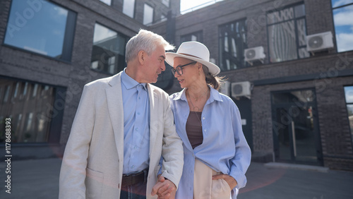 An elderly couple in love walks through the city.  photo