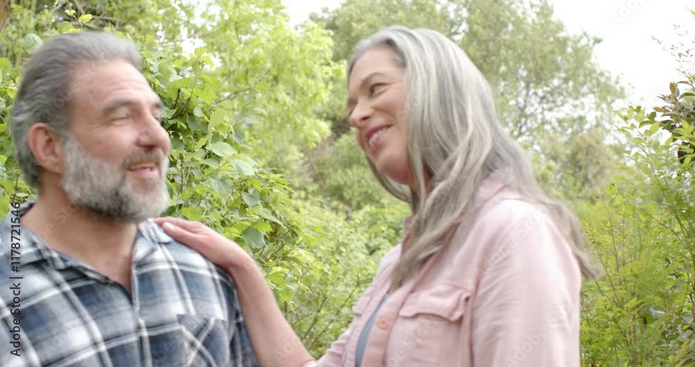 Happy mature couple embracing outdoors, enjoying nature and smiling together Happy mature couple embracing outdoors, enjoying nature and smiling together