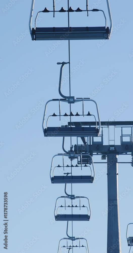 Ski lift chairs suspended above Kopaonik resort under a clear blue sky, showcasing winter recreation and serene landscape in the Serbian mountains Ski lift chairs suspended above Kopaonik resort under a clear blue sky, showcasing winter recreation and serene landscape in the Serbian mountains