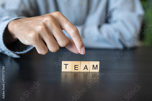 TEAM concept. Business man hand holding wooden cube words TEAM on a wood block
